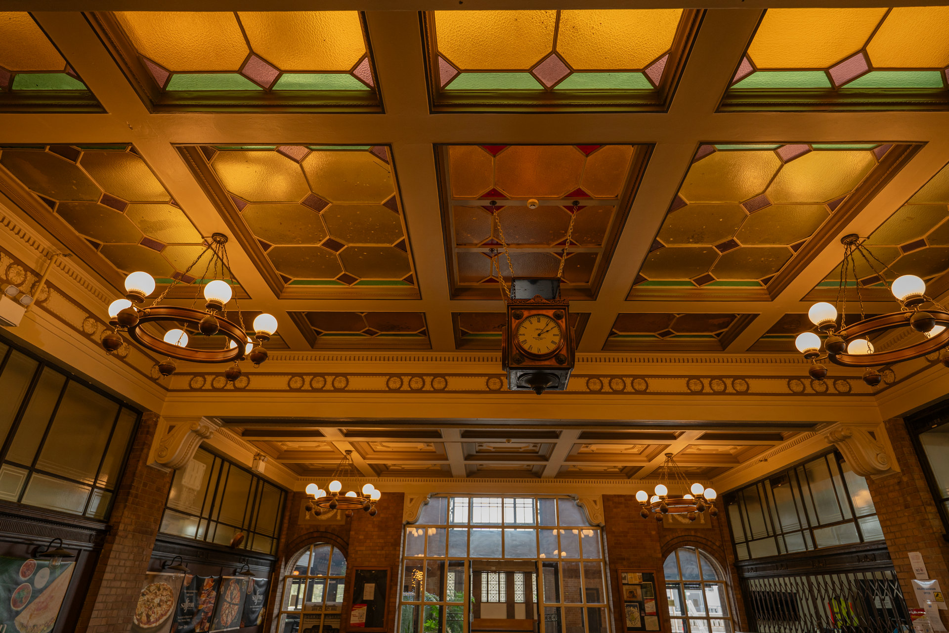 The stained-glass ceiling and clock in the Booking Hall.