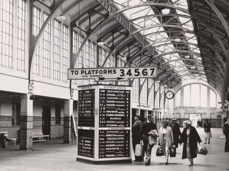 Passengers walking through the station concourse beside the departures board and signs to platforms 3 to 7.