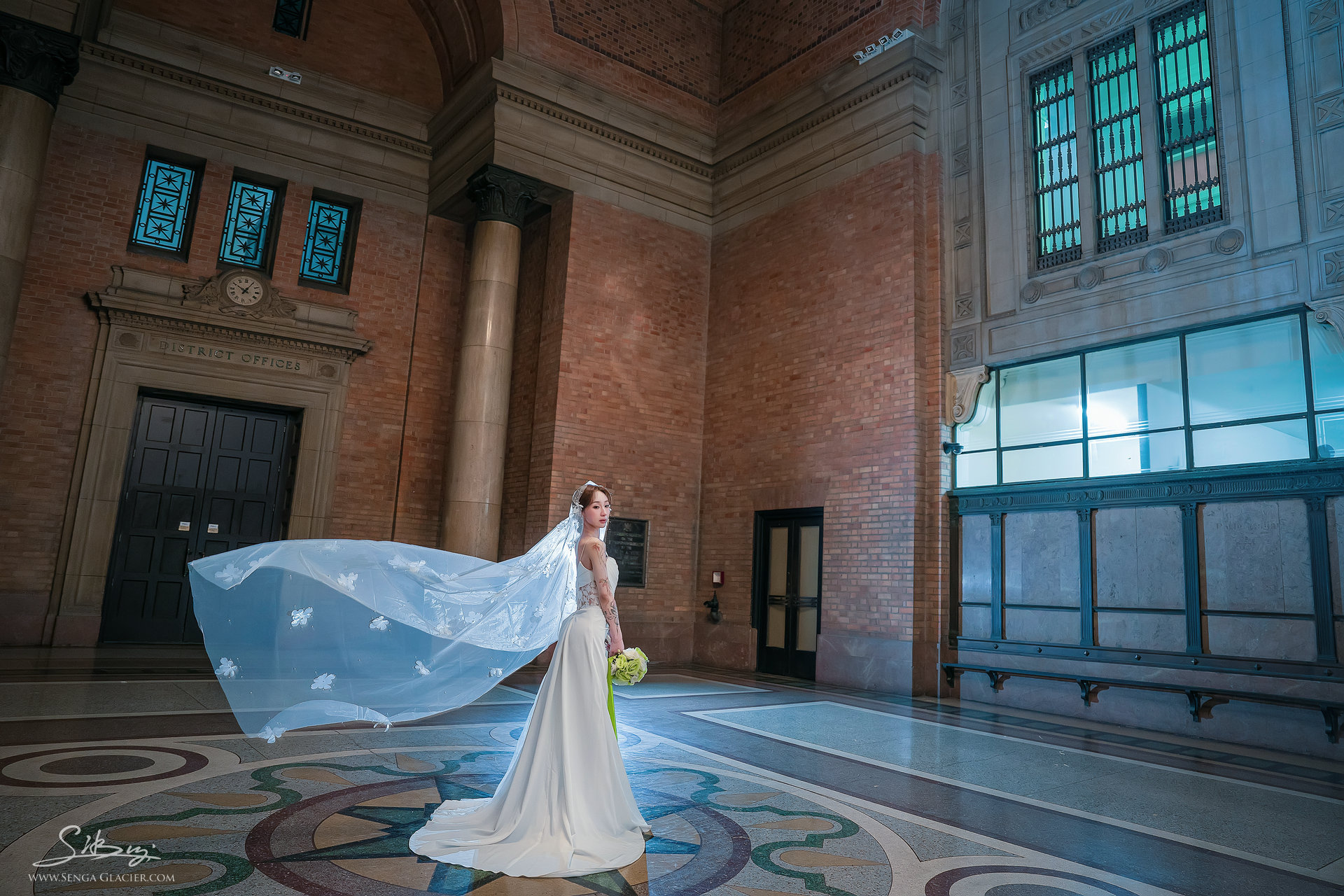 A bride with a flowing veil on the patterned foyer floor.