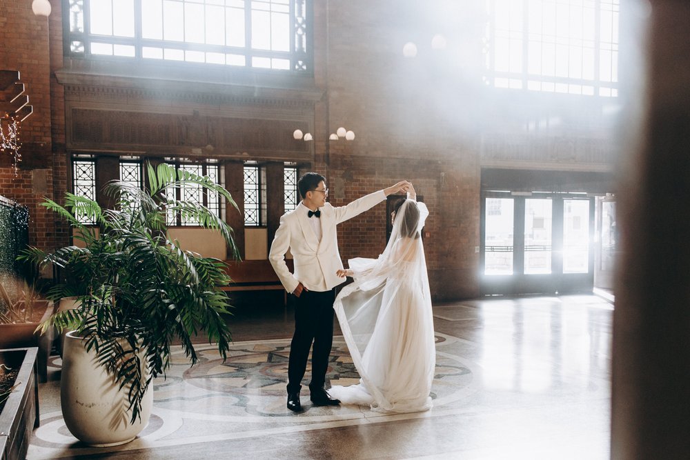 A couple dancing in sunlight across the Grand Hall floor.